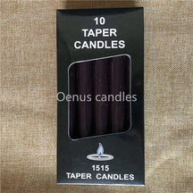 Black ritual candles arranged with their box, showing the dark wax colour and narrow cylindrical form.