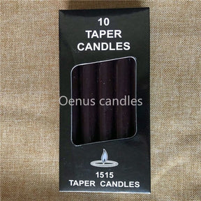 Black ritual candles arranged with their box, showing the dark wax colour and narrow cylindrical form.