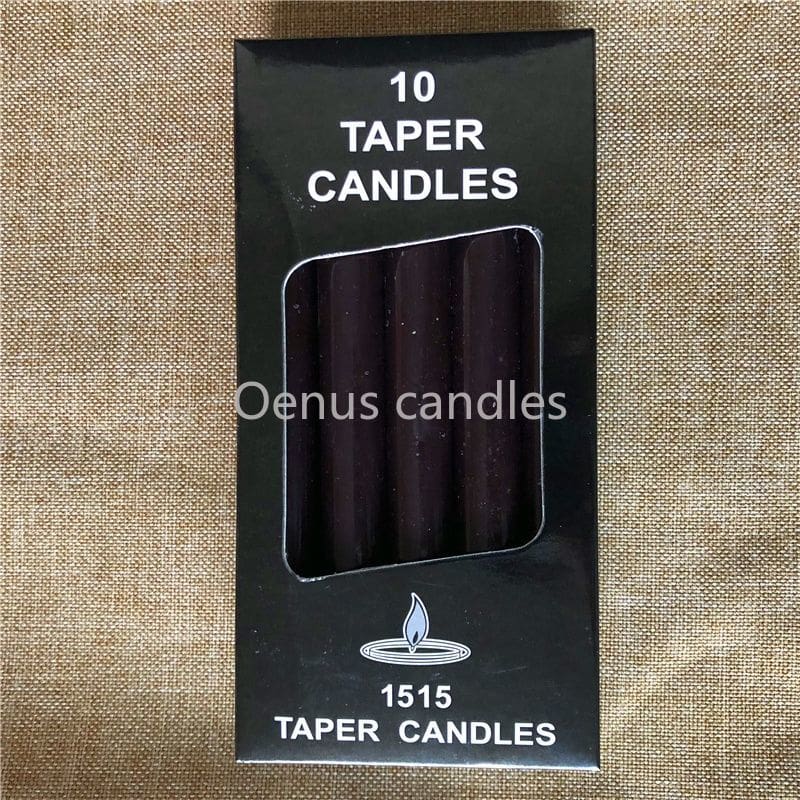Black ritual candles arranged with their box, showing the dark wax colour and narrow cylindrical form.
