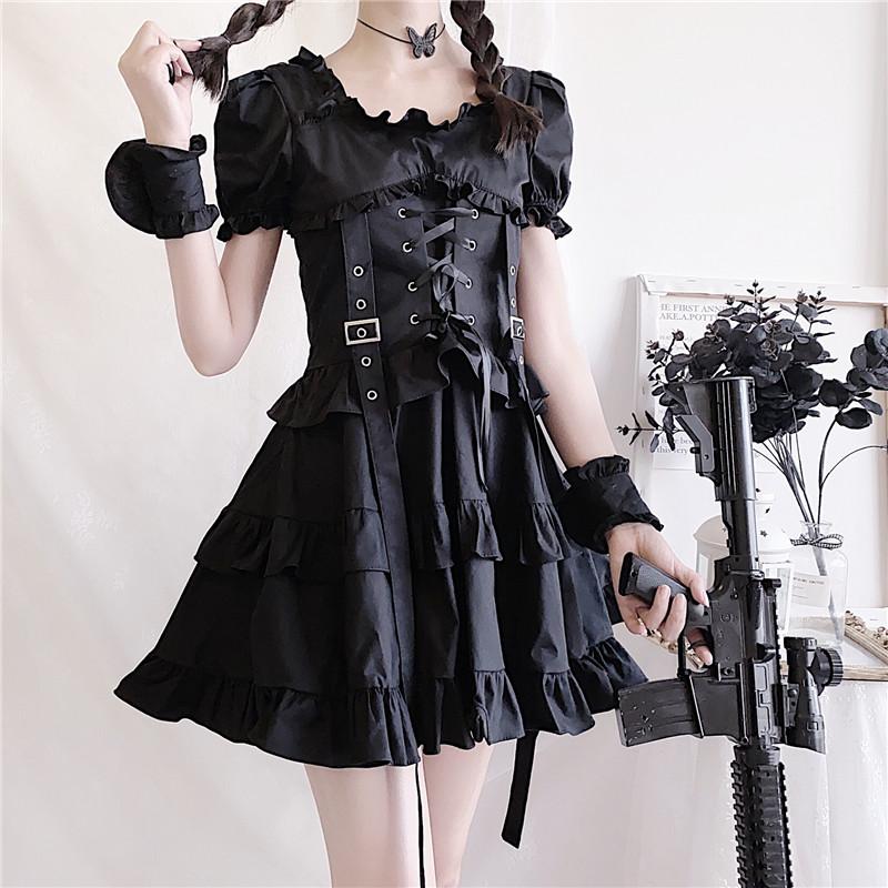 Black short-sleeved ruffle dress shown from the front with a laced corset harness, wide skirt and a costume prop held to one side.