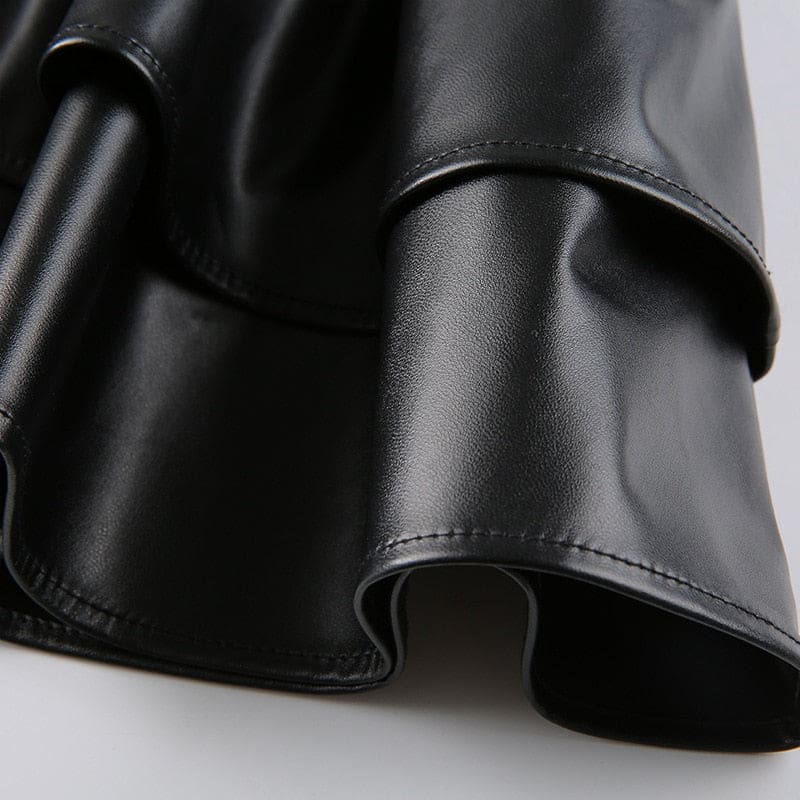 Close view of the glossy black faux leather folds in a ruffle tier, showing the surface shine and stitched edge.