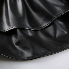 Detail of the black mini skirt’s two overlapping ruffle tiers and their curved stitched hems.