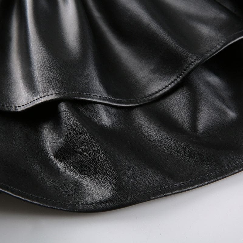Detail of the black mini skirt’s two overlapping ruffle tiers and their curved stitched hems.