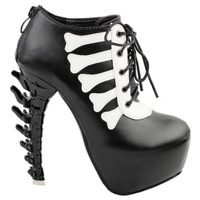 Black platform ankle boot in an outer-side view, showing pale bone-shaped trim, front laces and a sculpted black spine heel.