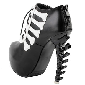 Black skeleton ankle boot viewed from the back and side, with the rear zipper, curved sole and spine-shaped heel visible.