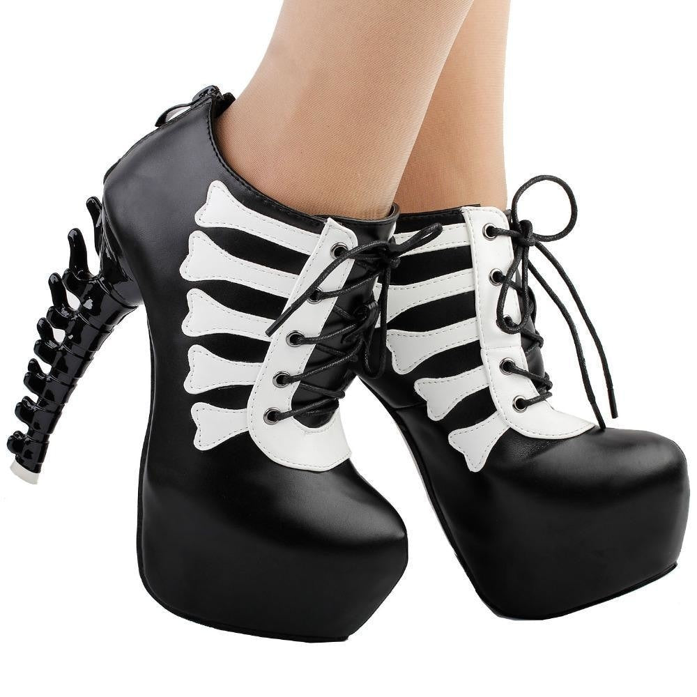 Black skeleton ankle boots worn from the front at a slight angle, showing their thick platforms and sculpted spine heels.