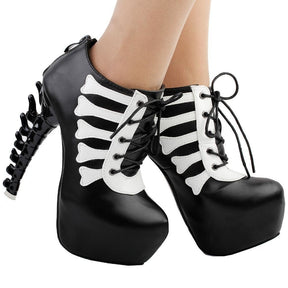 Black skeleton ankle boots worn from the front at a slight angle, showing their thick platforms and sculpted spine heels.