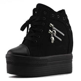Black high-top platform wedge sneaker shown alone with front laces, two silver-tone skull zipper pulls and a rounded toe cap.