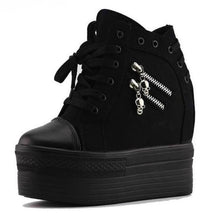 Black high-top platform wedge sneaker shown alone with front laces, two silver-tone skull zipper pulls and a rounded toe cap.