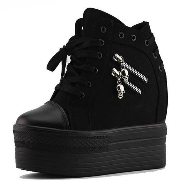 Black high-top platform wedge sneaker shown alone with front laces, two silver-tone skull zipper pulls and a rounded toe cap.