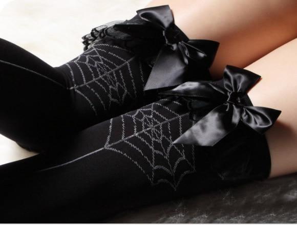 Black over-the-knee stockings with contrasting spiderweb patterns, dangling spider motifs, and black bows at the tops