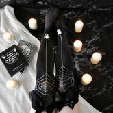Black over-the-knee stockings with contrasting spiderweb patterns, dangling spider motifs, and black bows at the tops