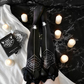 Black over-the-knee stockings with contrasting spiderweb patterns, dangling spider motifs, and black bows at the tops