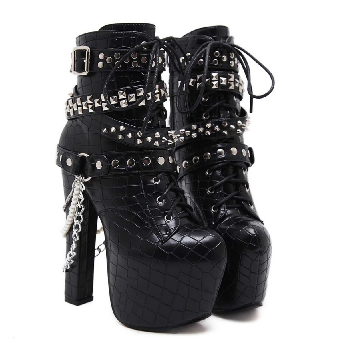 Pair of black reptile-textured platform ankle boots on white, with lace-up fronts, silver-tone studded straps, buckles and hanging chains beside tall block heels.