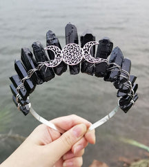 Front view of a black crystal point crown with a silver-tone triple moon emblem and wire-wrapped band.