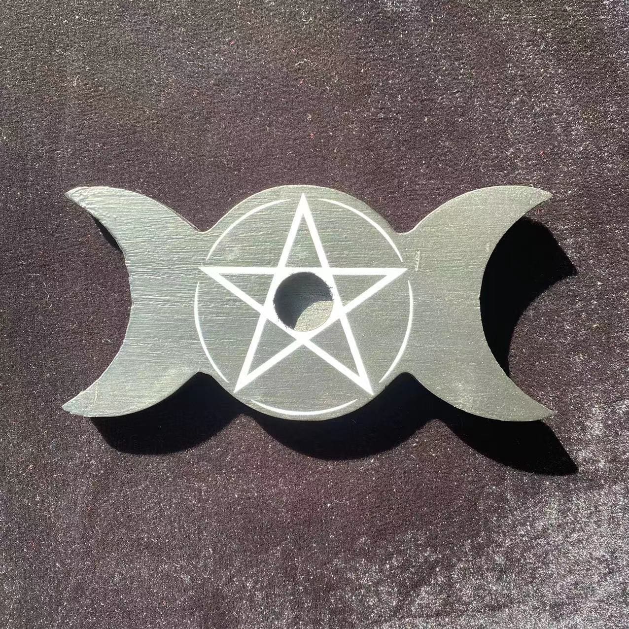Top view of the empty triple moon candle holder, showing one central candle opening inside the pale pentagram.