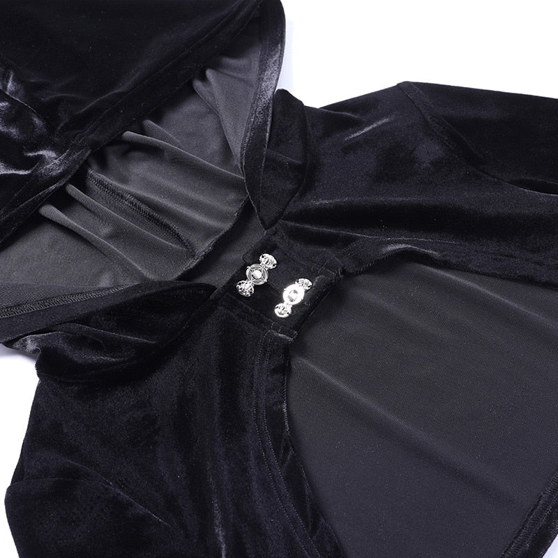 Close-up of the black velvet bolero's hood edge and two decorative silver-tone clasps above the curved front opening.