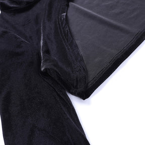 Close view of the black velvet bolero's curved hem and inner fabric surface beside the sleeve, showing the finished stitched edge.