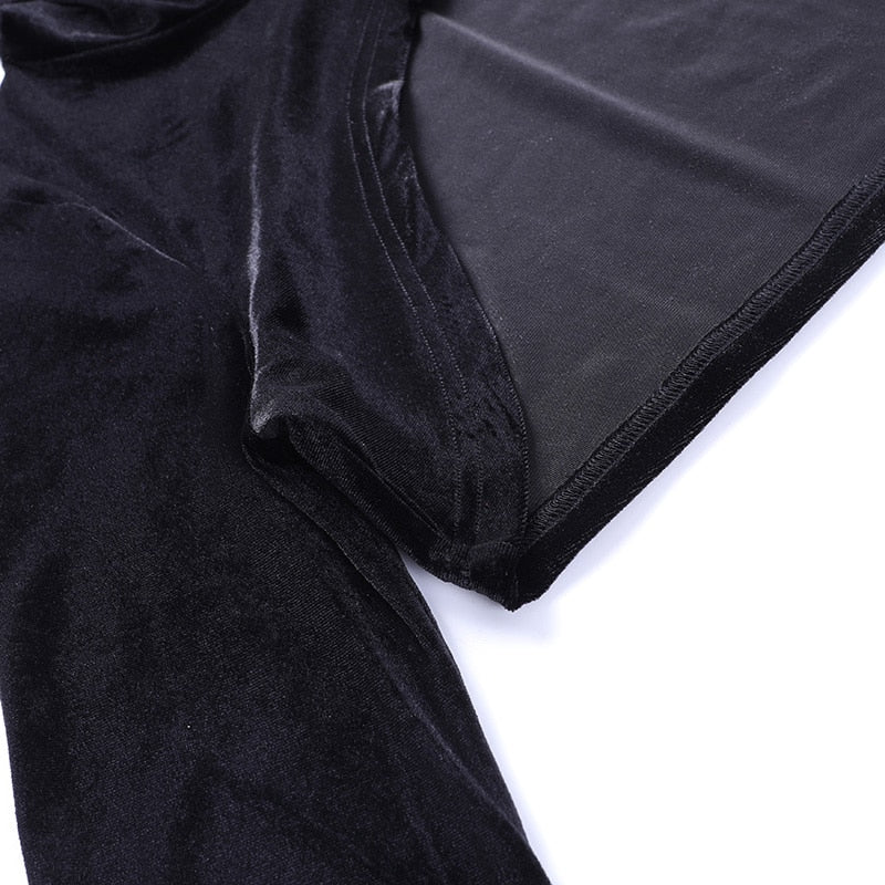 Close view of the black velvet bolero's curved hem and inner fabric surface beside the sleeve, showing the finished stitched edge.