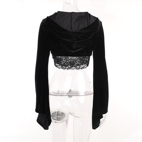 Rear view of the velvet bolero on a clear mannequin with the hood resting across the cropped back. A separate lace camisole extends below the hem.