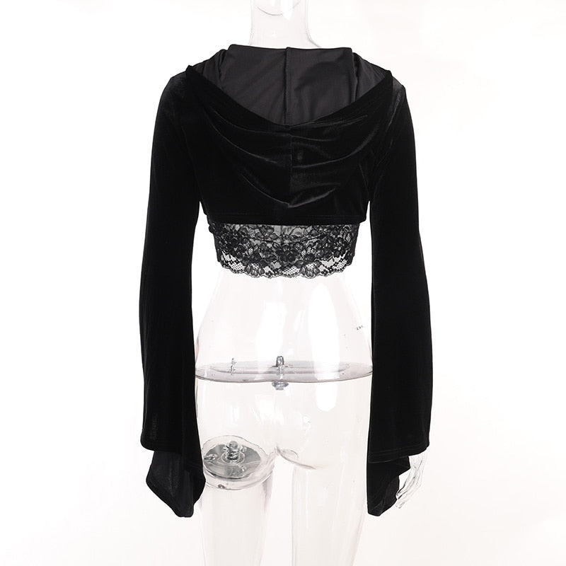 Rear view of the velvet bolero on a clear mannequin with the hood resting across the cropped back. A separate lace camisole extends below the hem.