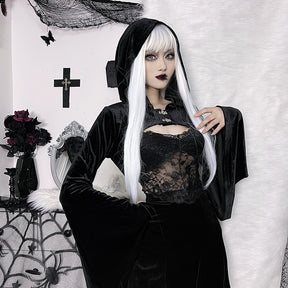 Model with long white hair wearing the hooded black velvet overlay, one hand lifted near the chest. A lace camisole and short skirt complete the styled outfit.
