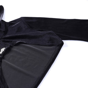 Detail of the black velvet overlay laid flat, showing the shoulder, sleeve seam and curved edge of the short body.