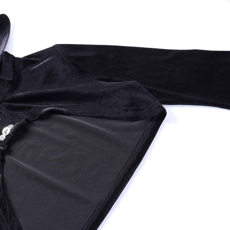 Detail of the black velvet overlay laid flat, showing the shoulder, sleeve seam and curved edge of the short body.