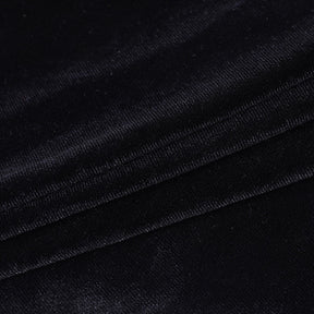 Close-up of black velvet fabric on the bolero, showing its short pile, directional sheen and stitched edge.