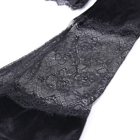 Close-up of a sheer floral lace insert joining sections of black velvet along a bell sleeve, showing the fine mesh and scalloped pattern.