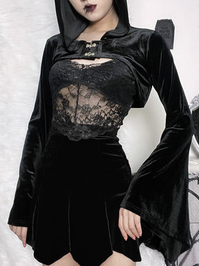 The black velvet hooded bolero styled over a lace camisole and short black skirt, with the arms lowered to show the long pointed bell cuffs.