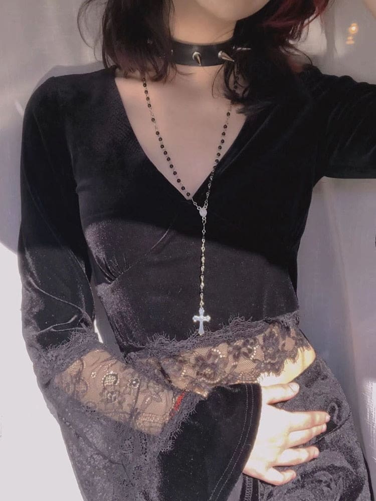 A model wears the deep V-neck velvet crop top with a long pendant necklace, showing the wide lace hem and one sweeping cuff.