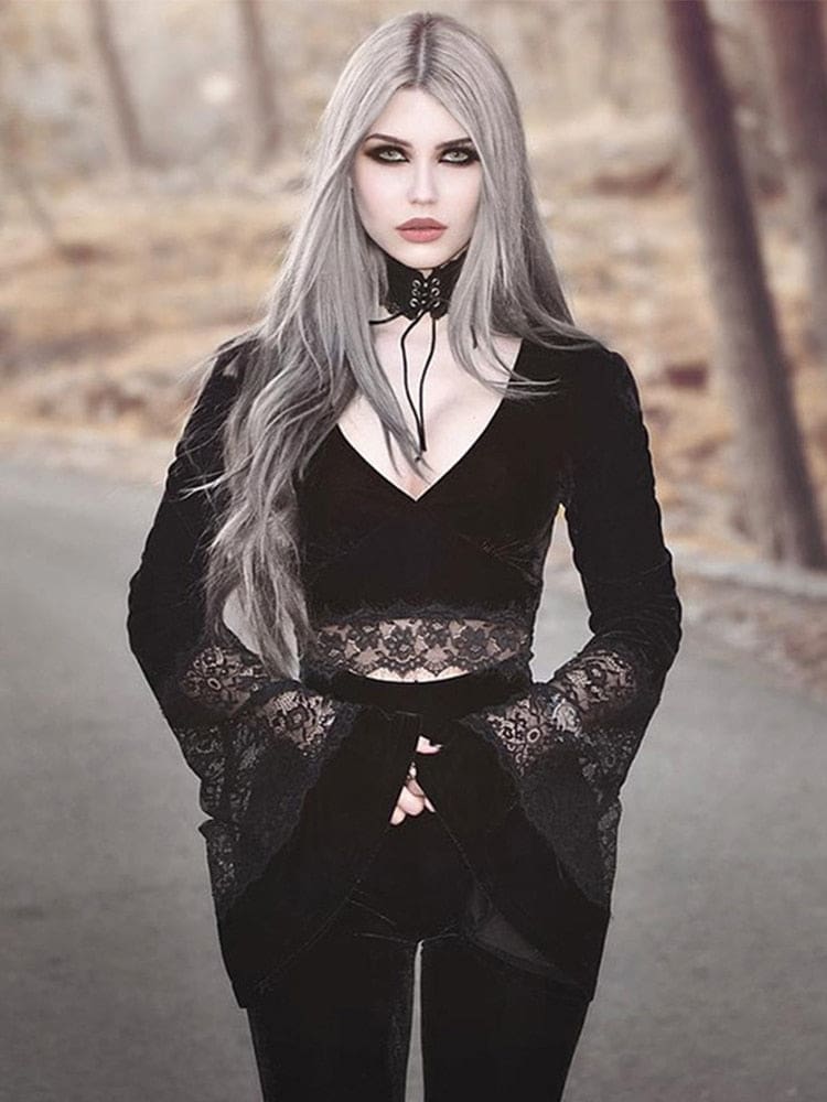 Silver-haired model wearing the black velvet and lace crop top outdoors with dark trousers, holding the long bell cuffs in front.