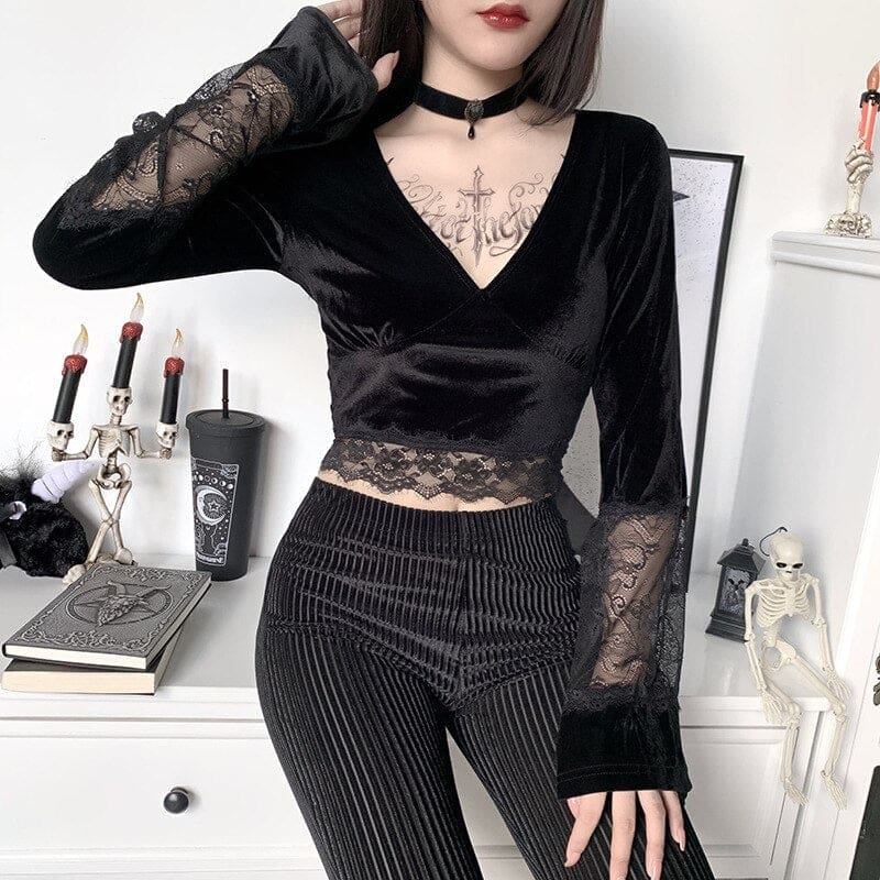 Model wearing the V-neck velvet crop top with one hand behind the head, highlighting the sheer lace sleeve panel and scalloped cropped hem.