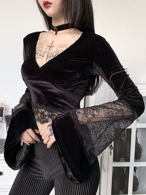 Black velvet V-neck crop top worn with pinstripe trousers, showing scalloped lace at the waist and sheer lace panels above the flared cuffs.