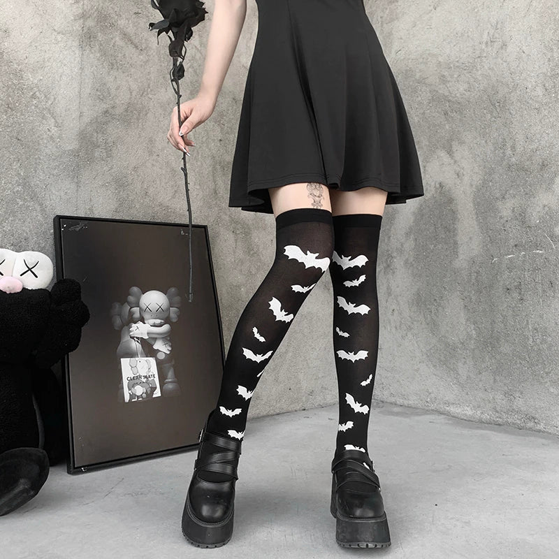 Black over-the-knee stockings with white bats worn with a short black dress and chunky shoes.
