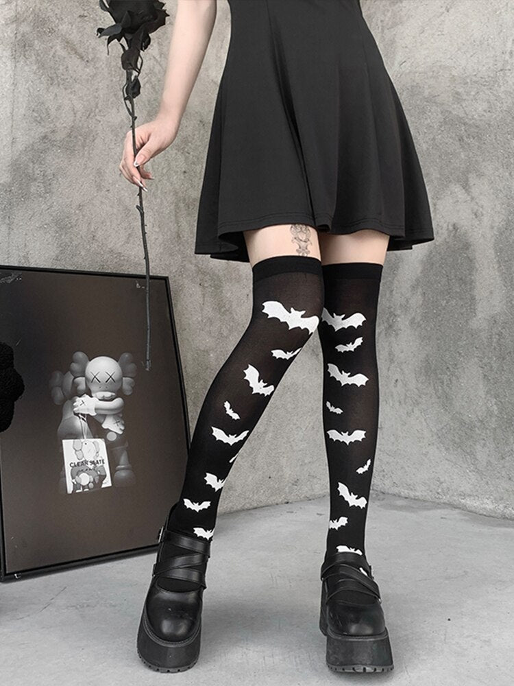Black over-the-knee stockings with white bats shown in a full leg outfit view.
