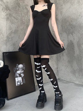 Black over-the-knee stockings with white bats paired with a black dress in a wider outfit view.