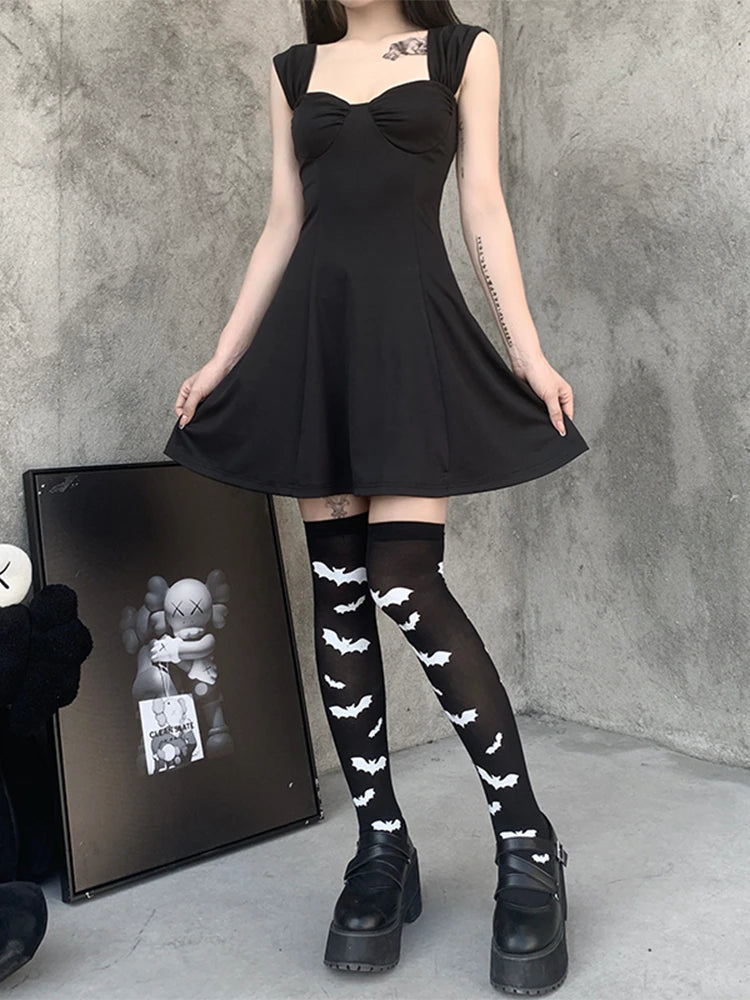 Black over-the-knee stockings with white bats paired with a black dress in a wider outfit view.