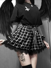 Black high-waisted skort worn from the front, with a white grid pattern flaring over the short hem and scalloped black lace beneath. A striped sleeve and studded belt complete the styled outfit.