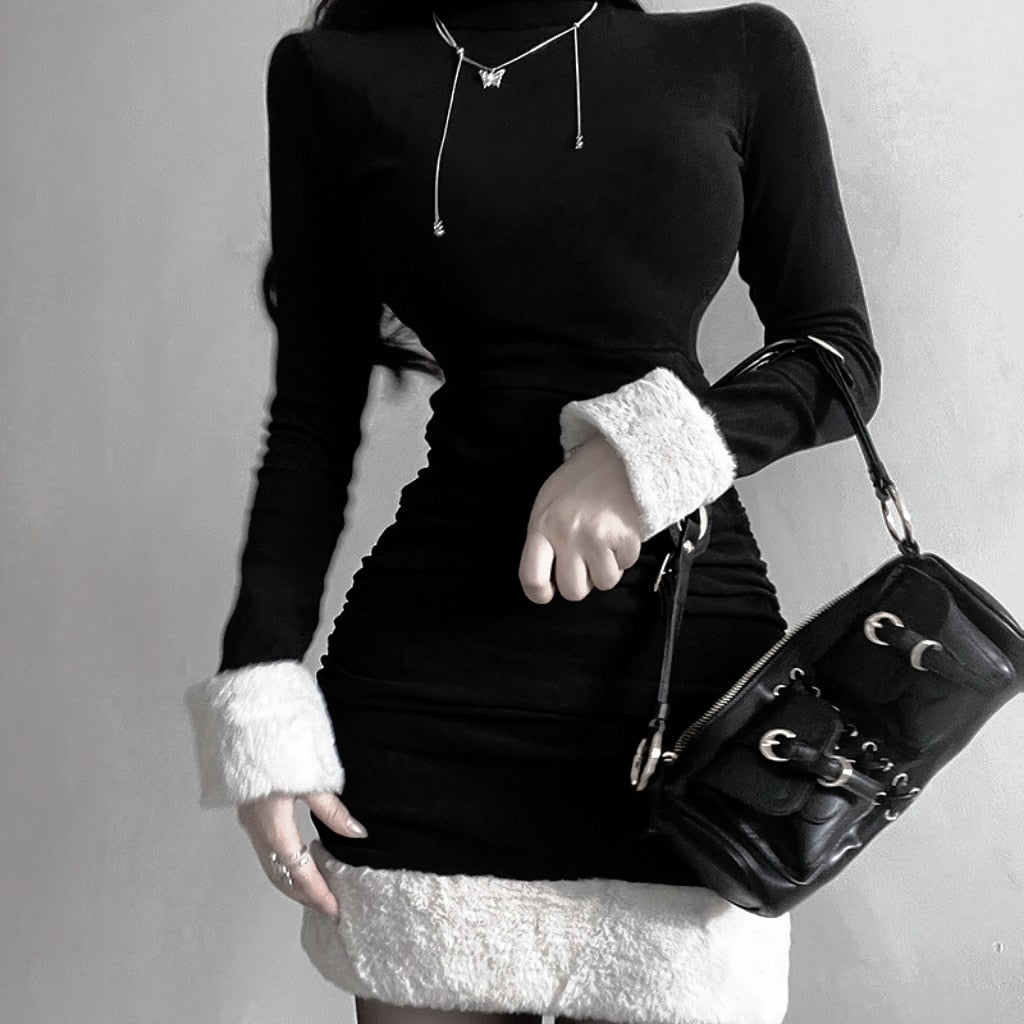 Black holiday mini dress with white fluffy cuffs and hem paired with a black shoulder bag.