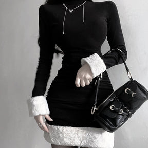 Black holiday mini dress with white fluffy cuffs and hem paired with a black shoulder bag.