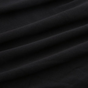 Black holiday mini dress with white fluffy cuffs and hem with the black ribbed fabric shown in folds.