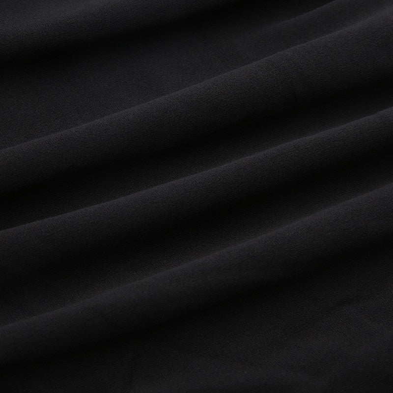 Black holiday mini dress with white fluffy cuffs and hem with the black ribbed fabric shown in folds.