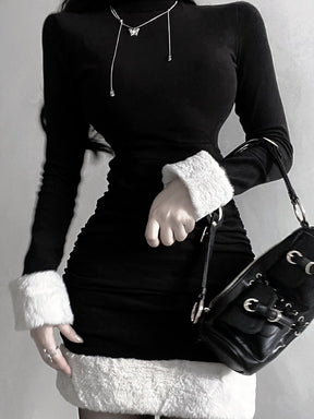 Black holiday mini dress with white fluffy cuffs and hem styled with a black bag, front view.