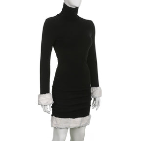 Black holiday mini dress with white fluffy cuffs and hem displayed at a three-quarter angle.