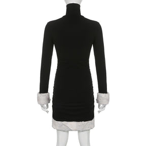Black holiday mini dress with white fluffy cuffs and hem displayed from the back.