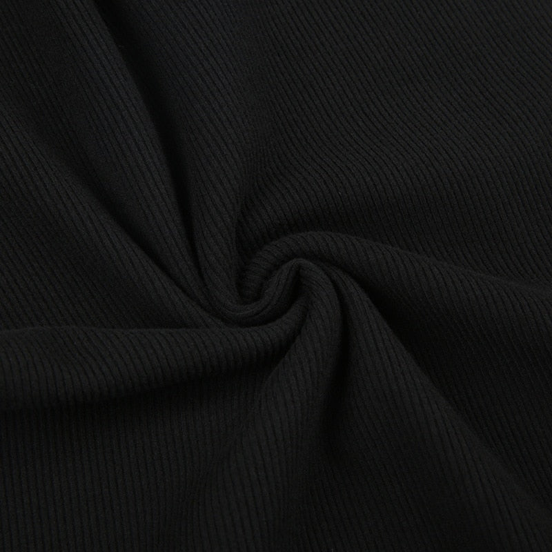 Black holiday mini dress with white fluffy cuffs and hem with a close view of the fine black ribbed texture.