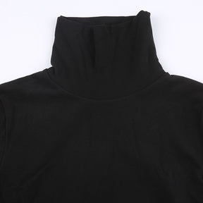 Black holiday mini dress with white fluffy cuffs and hem with a close view of the ribbed high neckline.
