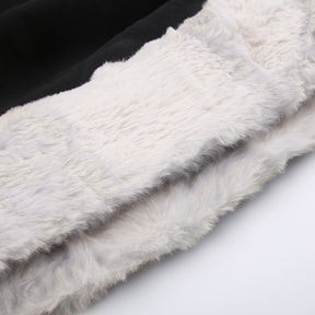 Black holiday mini dress with white fluffy cuffs and hem with a close view of the fluffy white hem trim.